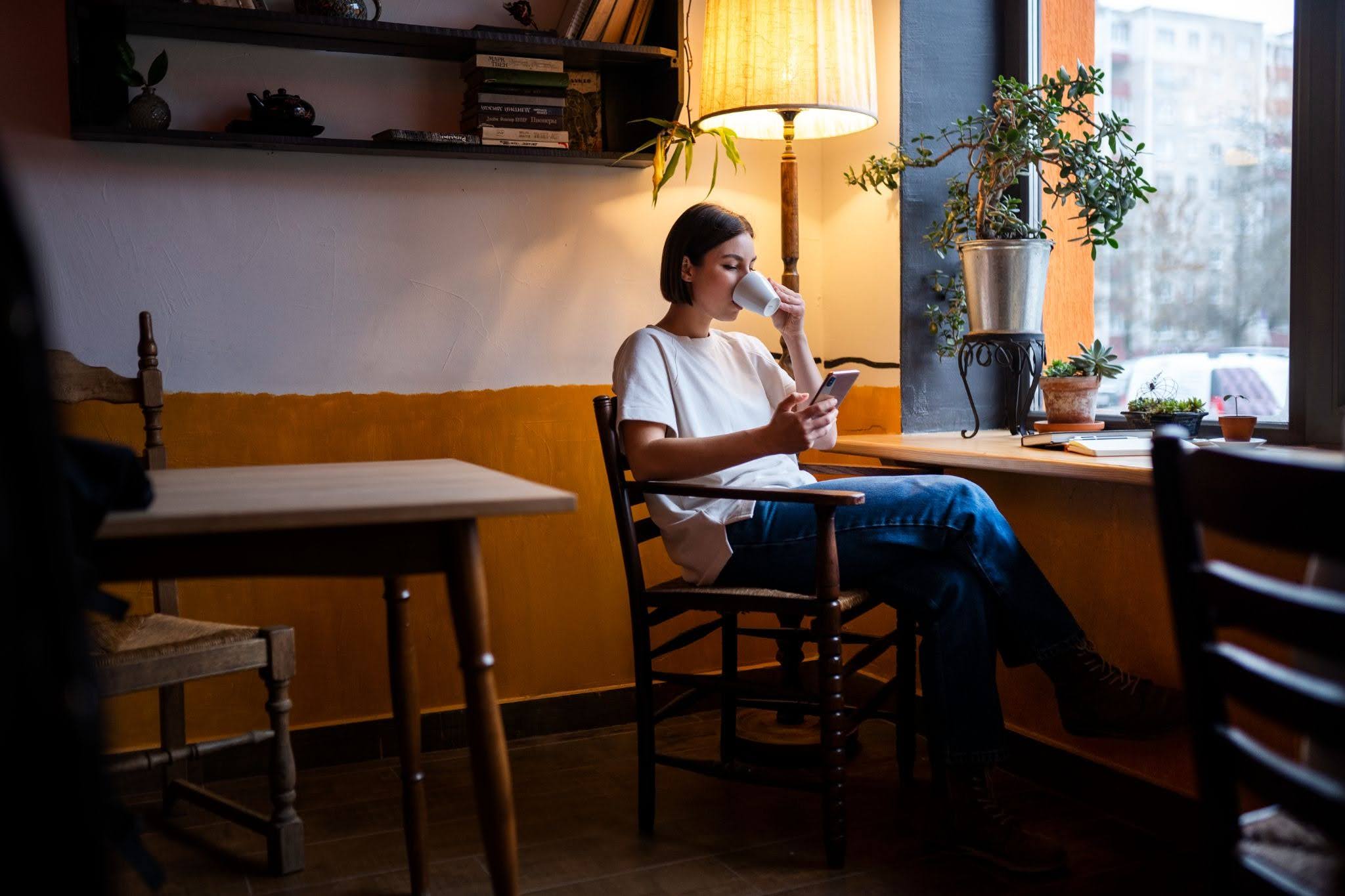 Person in a café enjoying a book and drinking coffee