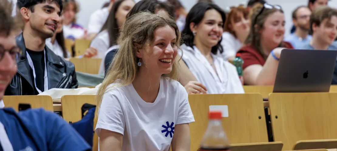 Young people listening and smiling in an auditorium