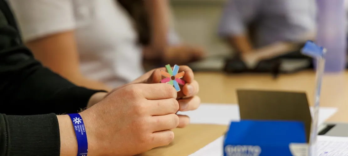 A hand holding the pin of ESN logo