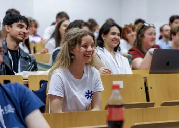 Young people listening and smiling in an auditorium