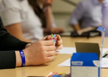 A hand holding the pin of ESN logo