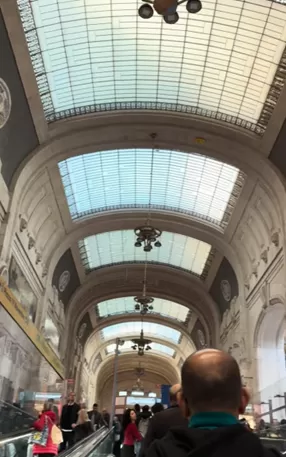 A view of the high, vaulted glass and steel ceilings inside the monumental Milano Centrale station.