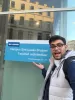 A selfie of me pointing to the blue KU Leuven Faculty of Architecture sign in Brussels.