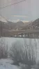 Cinematic snow covered mountains and a bridge seen from a moving train.