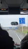 View from the front of a bus showing a blue road sign pointing toward Brussels.
