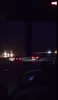 A night view from a vehicle of car tail lights on a dark highway.