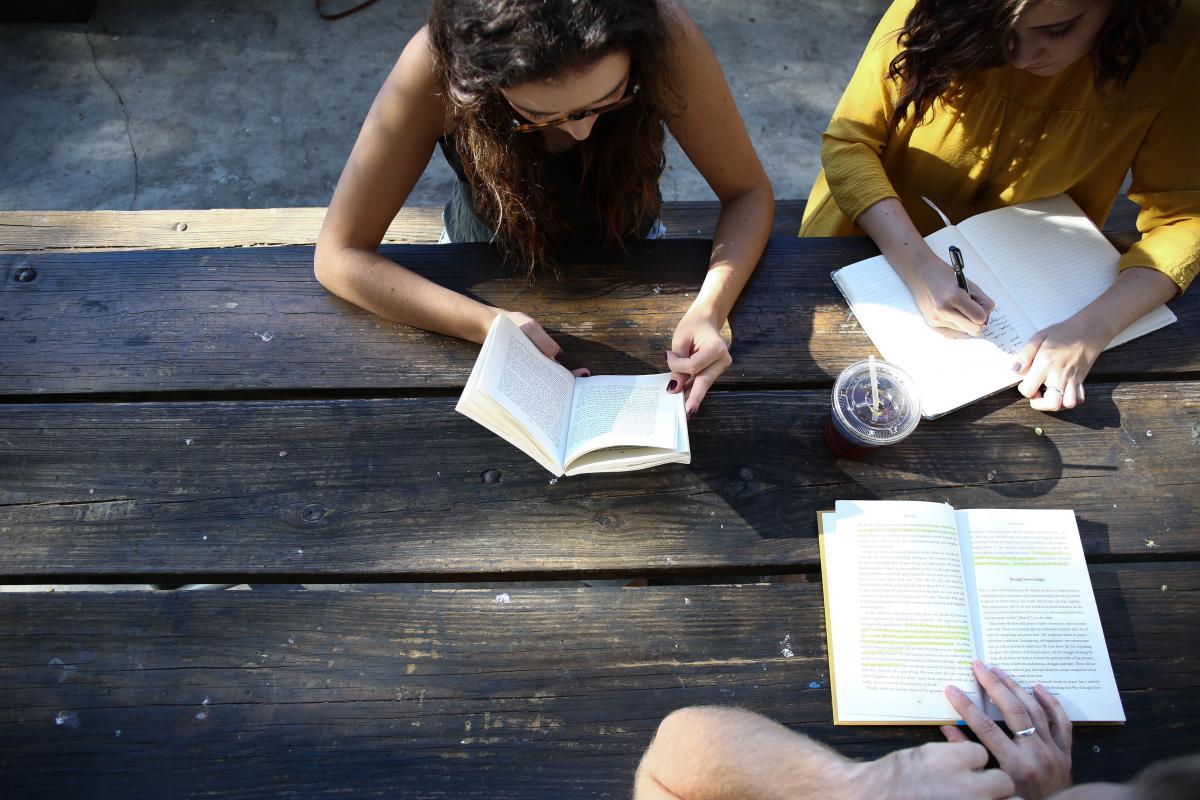 3 girls reading on table