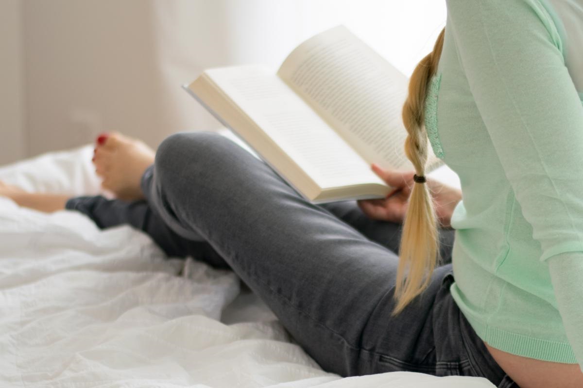 someone reading a book on bed