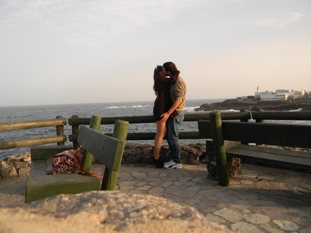 couple kissing by the coast