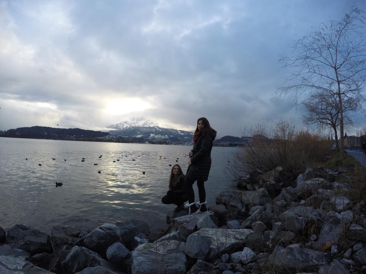 people on rocks in front of lake