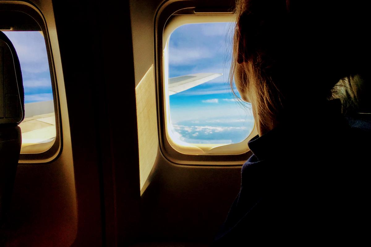 someone on a plane looking at window