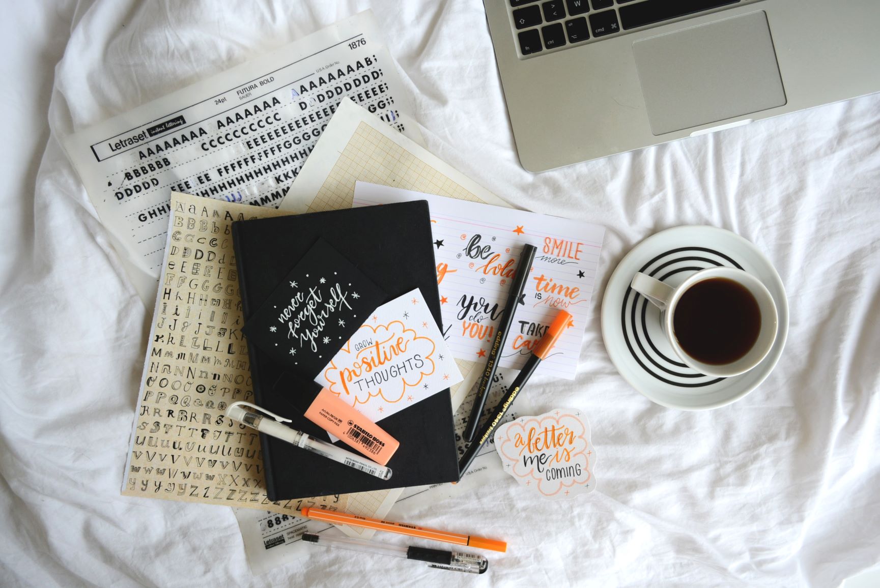 notebook and coffee on bed