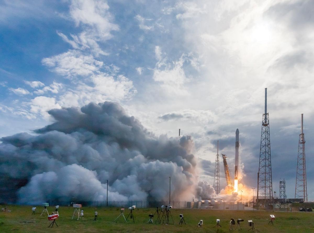 rocket launch with a lot of smoke and telescopes around