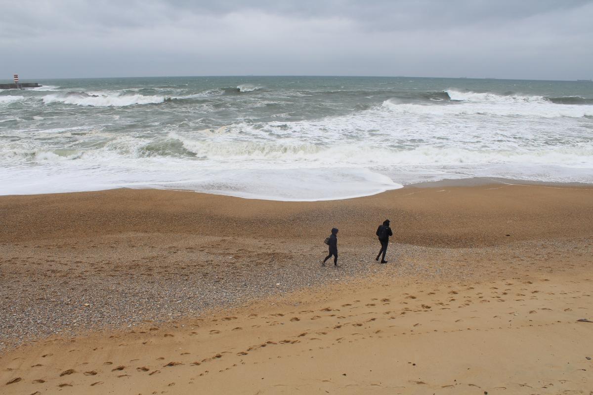 two people walking on the beach, view from top