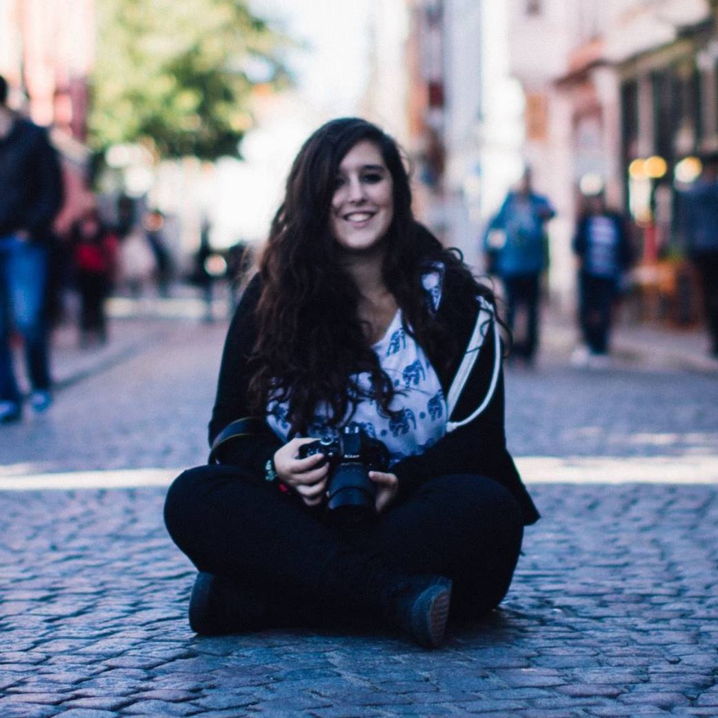 woman with camera sitting on the street