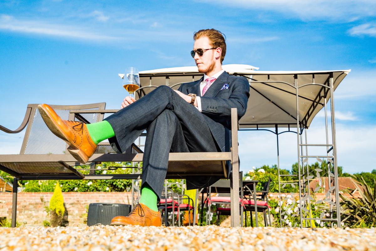 guy in suit on terrace with glass of wine