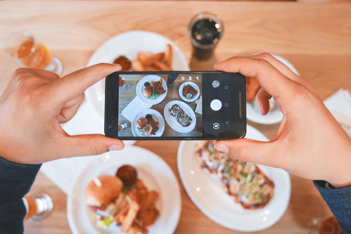 someone taking picture of plates of food