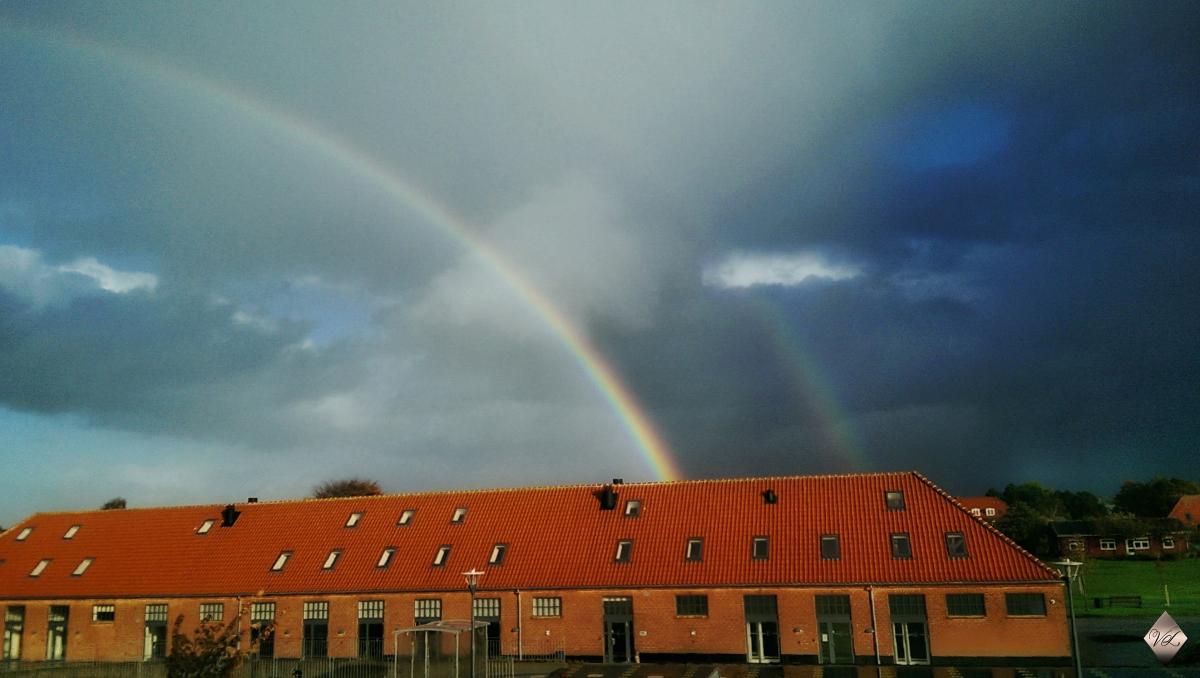 rainbow in sly with building below