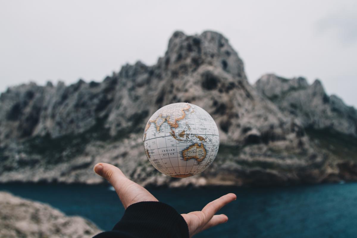 hand lifting up a globe