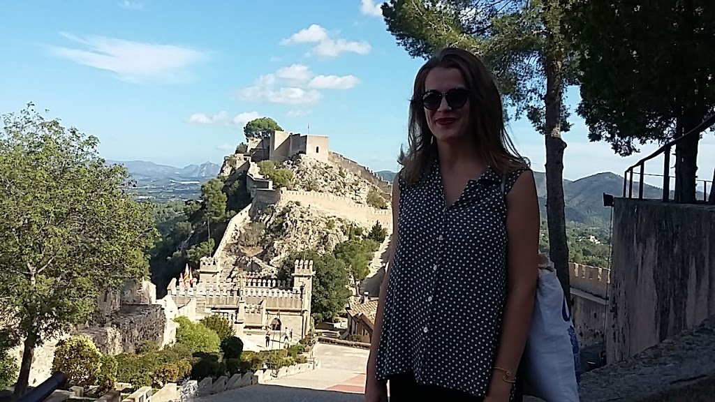 woman posing with ancient building in the back