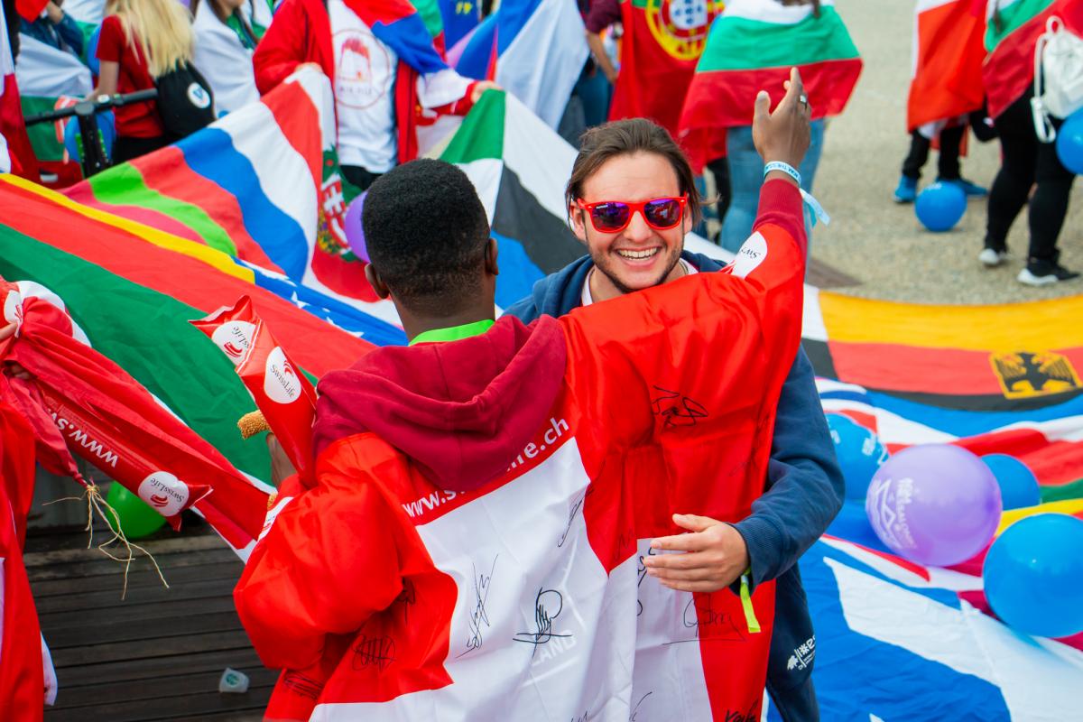 people hugging at esn event with flags around