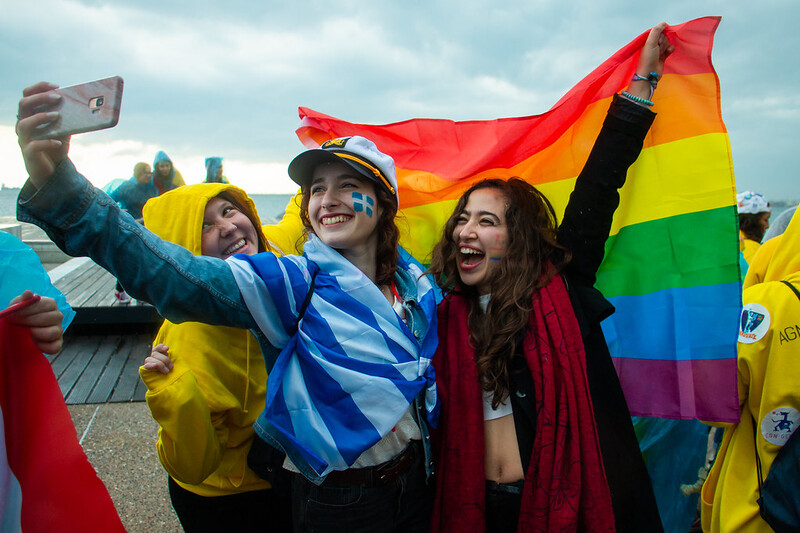 women taking selfie with rainbow flag