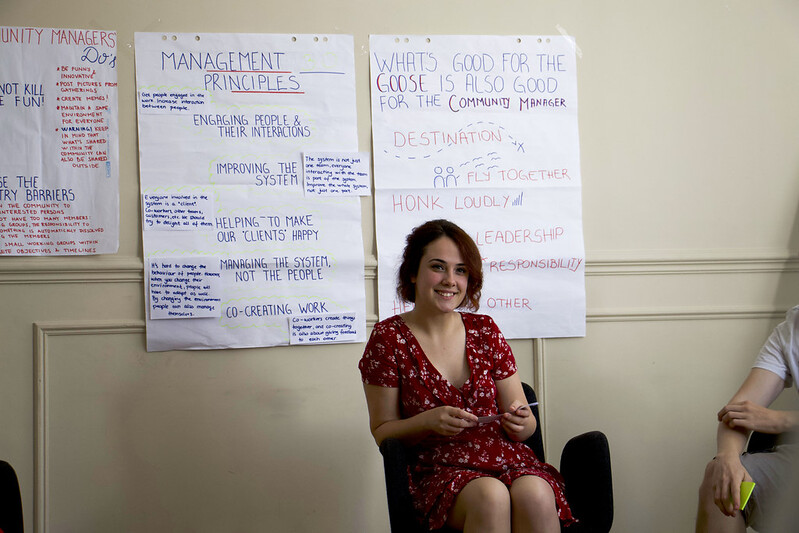 woman sitting with posters behind