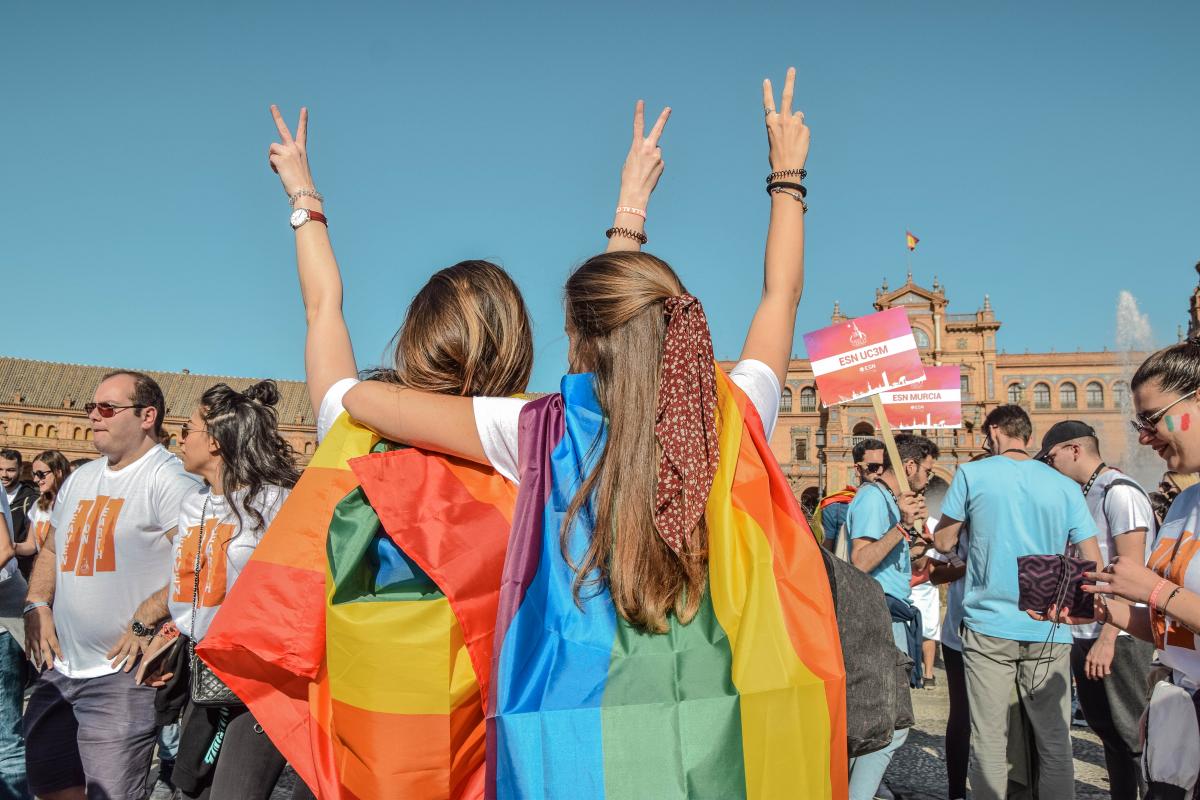 people doing peace sign with rainbow flags