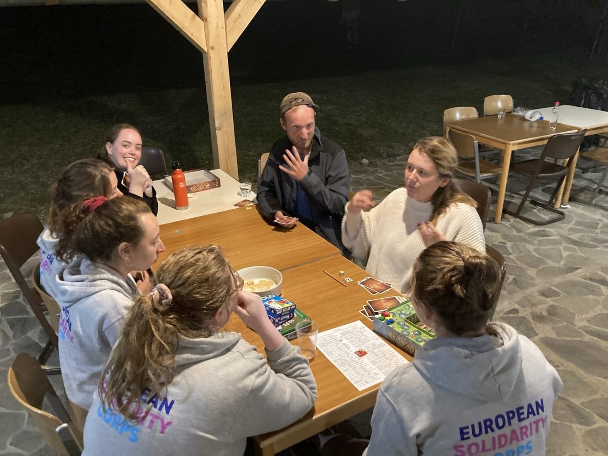 people talking and playing cards at table