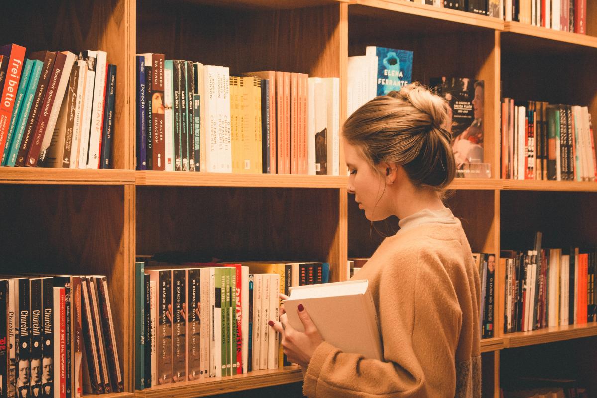 woman looking at books in bookshelves