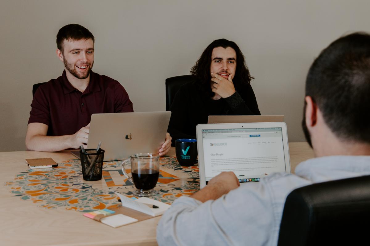 men working with laptops at table