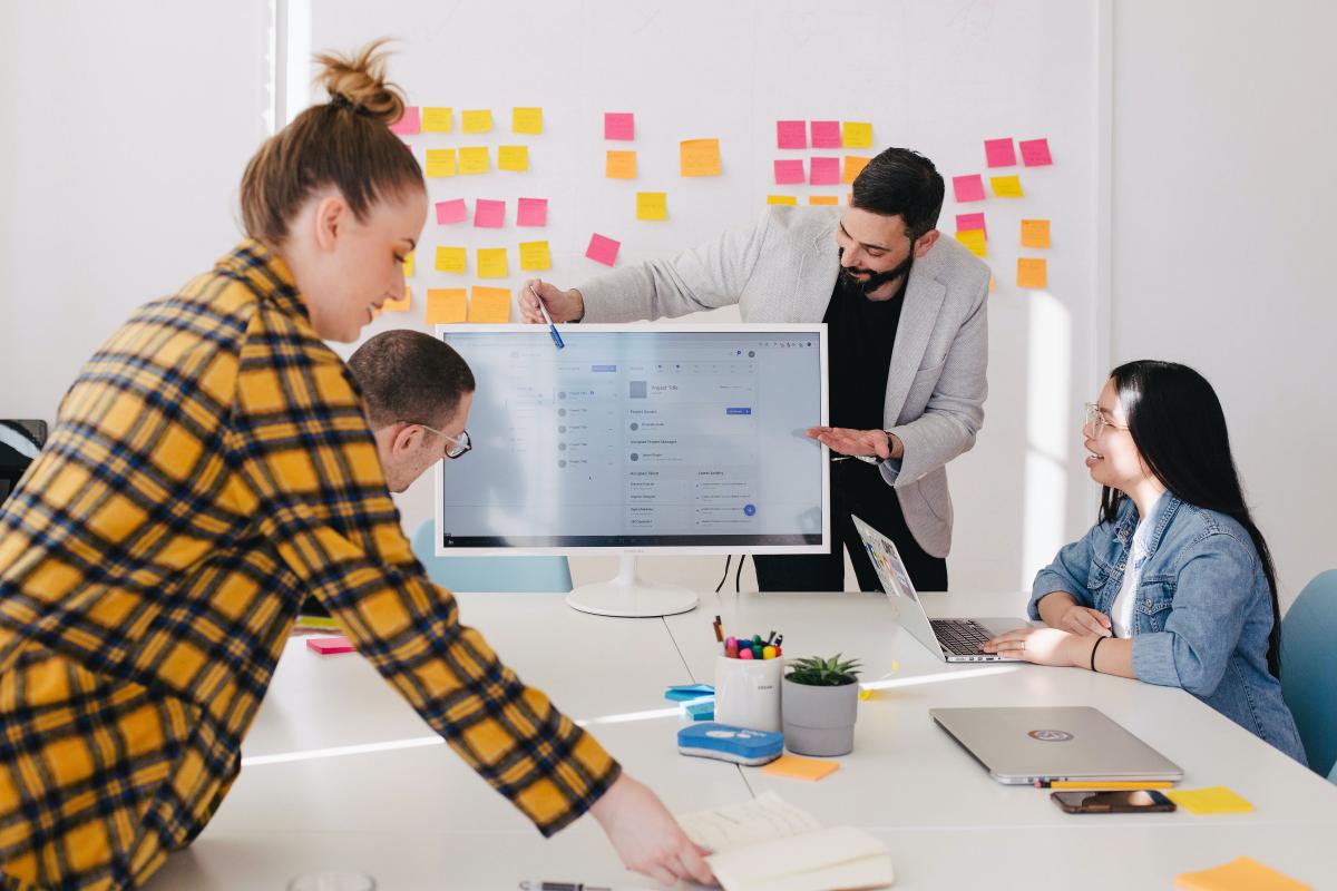 people working together with screen and post-its on the wall