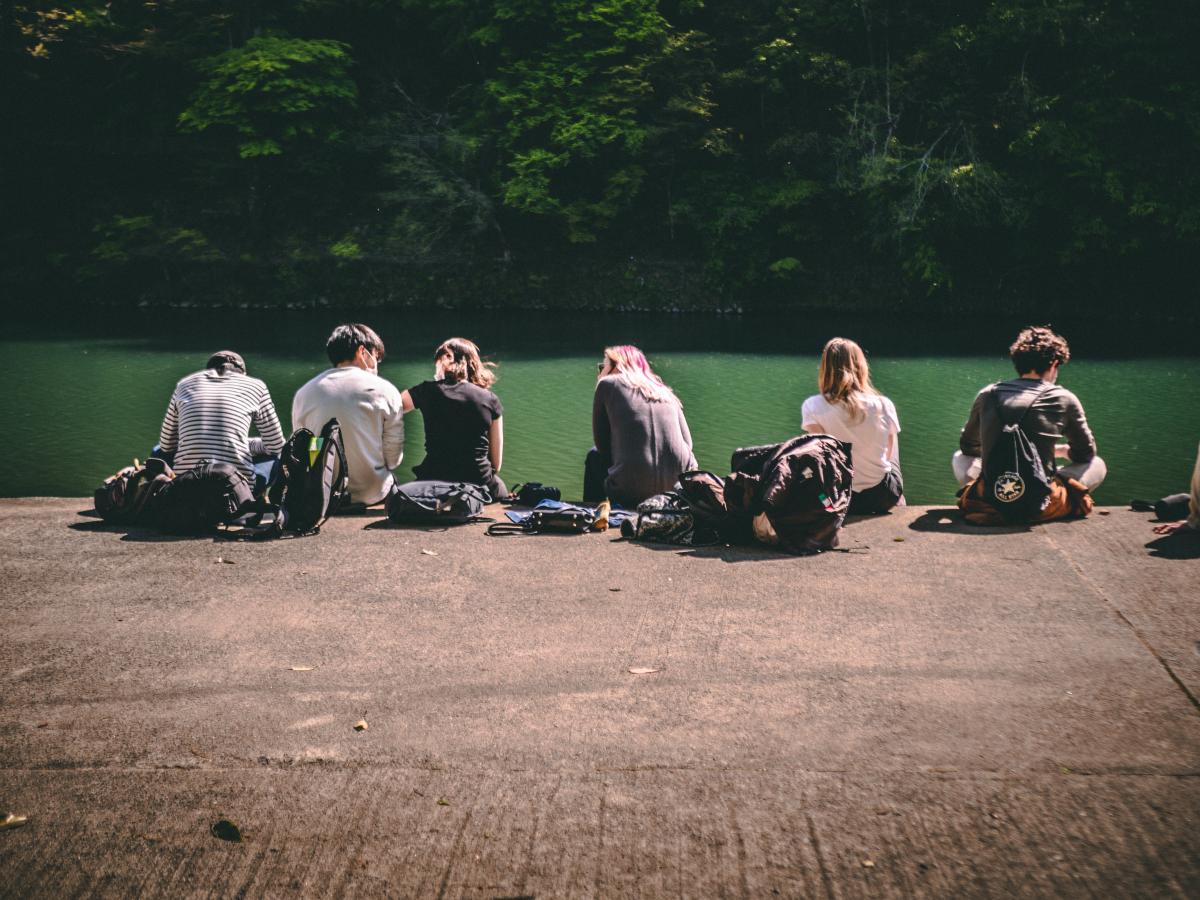 people sitting in front of river