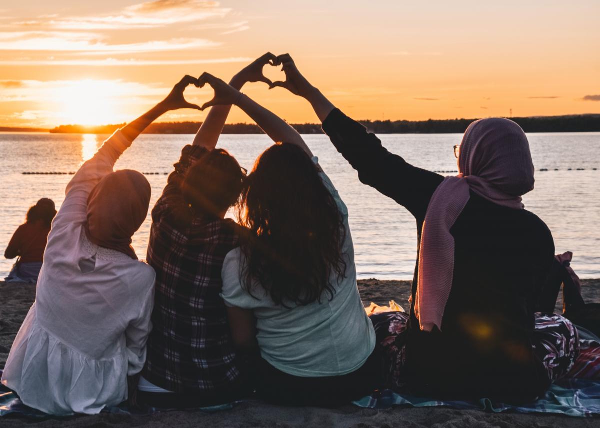 people looking at sunset, doing hearts with hands
