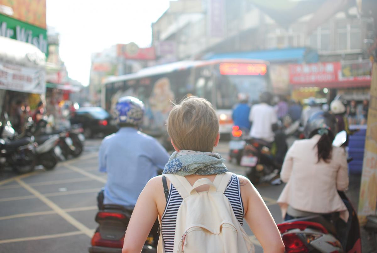 woman walking in crowded street, from back