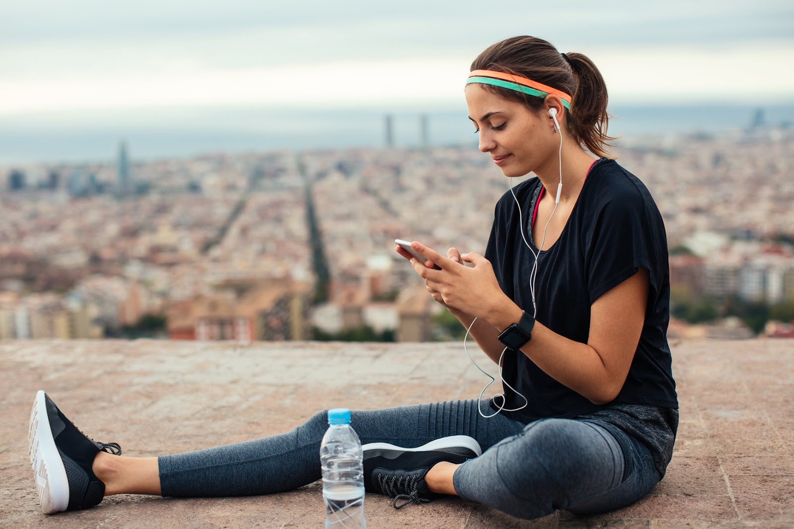 typing on phone, sitting in sport outfit