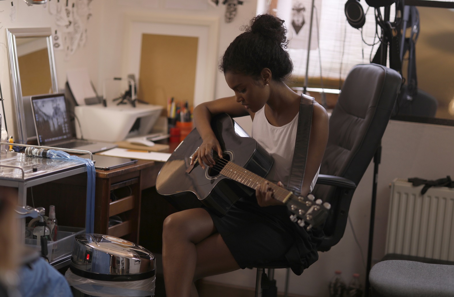 woman in white tank top playing acoustic guitar