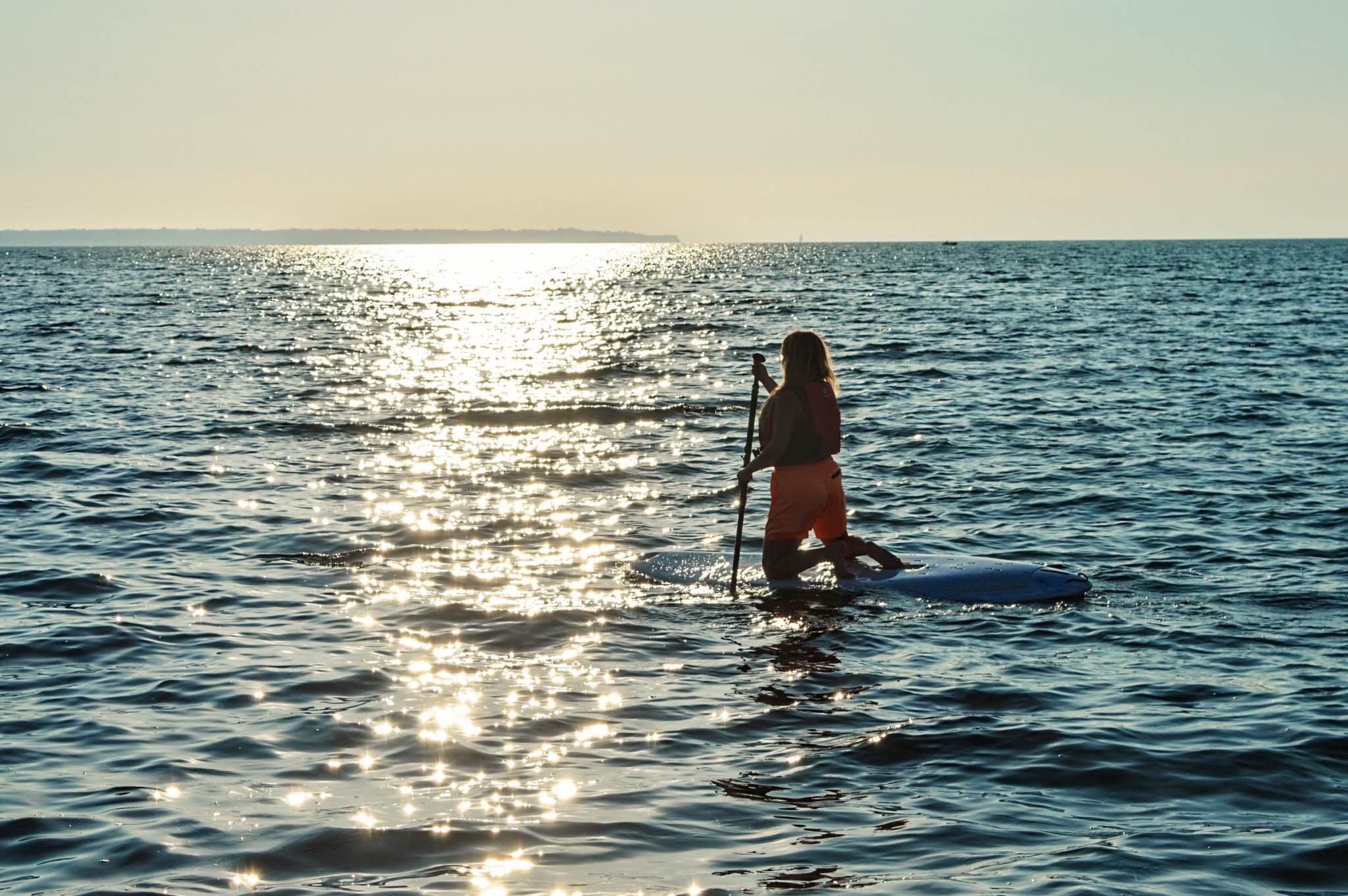 A girl doing paddle boarding in the sea