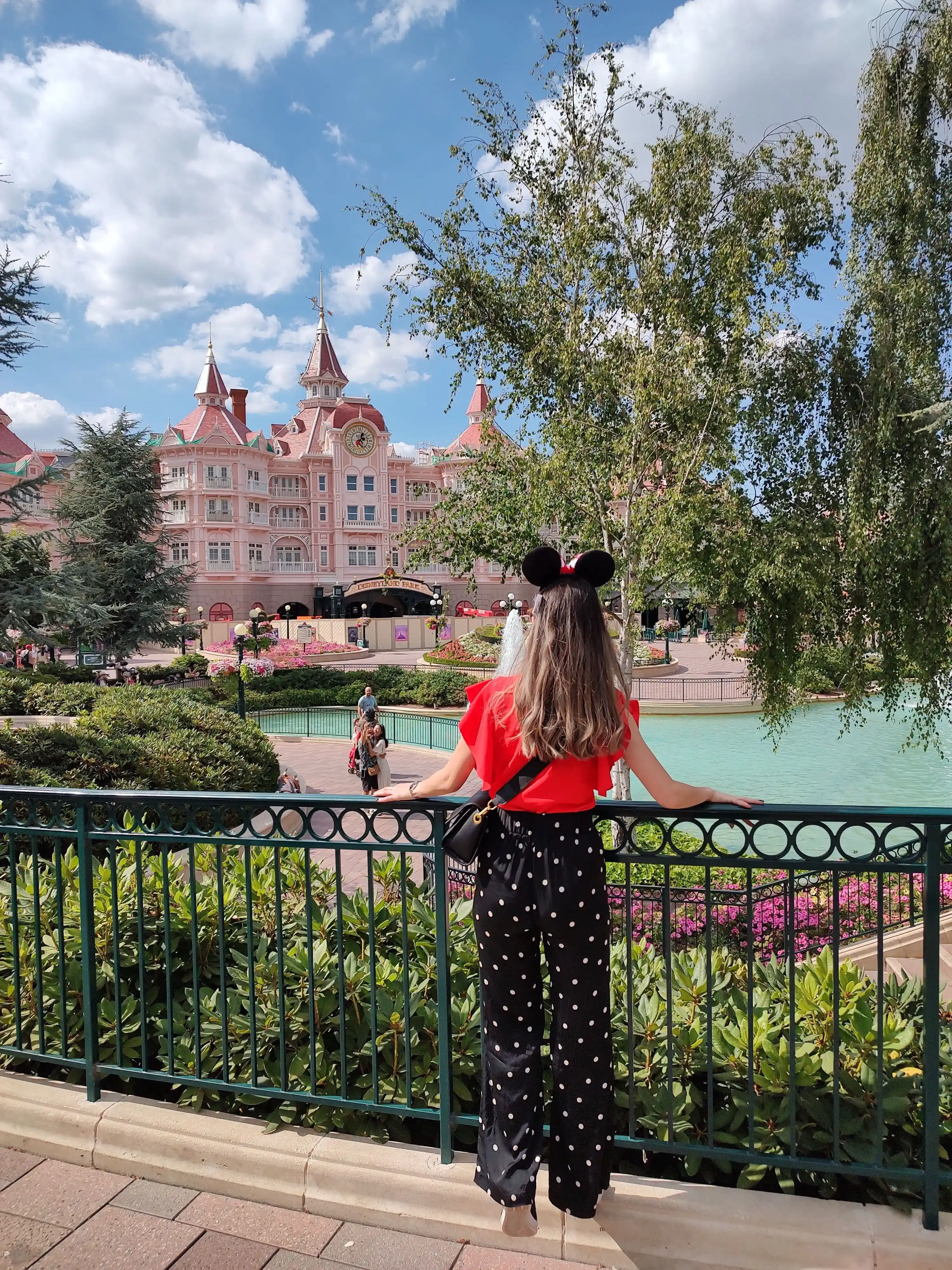 A girl standing and watching the Disneyland castle