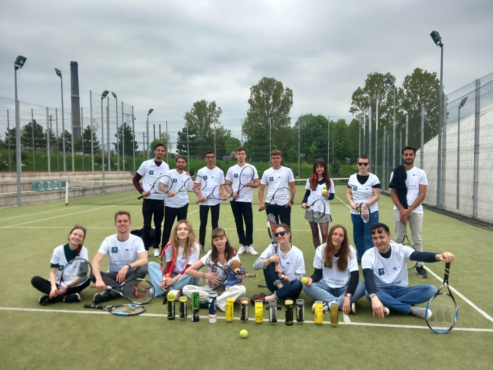 A group of Participants of the youth project is psoing to a photo on a football pitch.