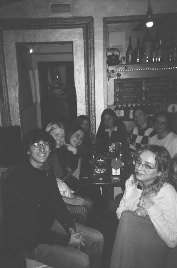 Black and white picture of a group of young people sitting in a bar