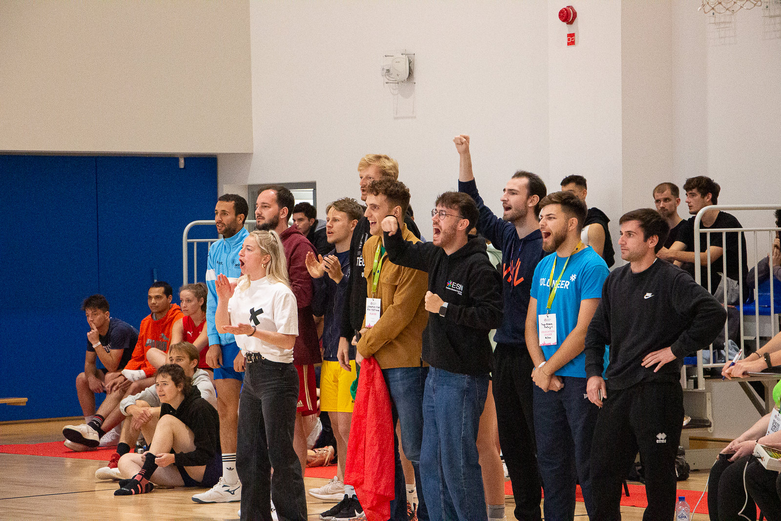 A group of young people cheering at a basketball game.