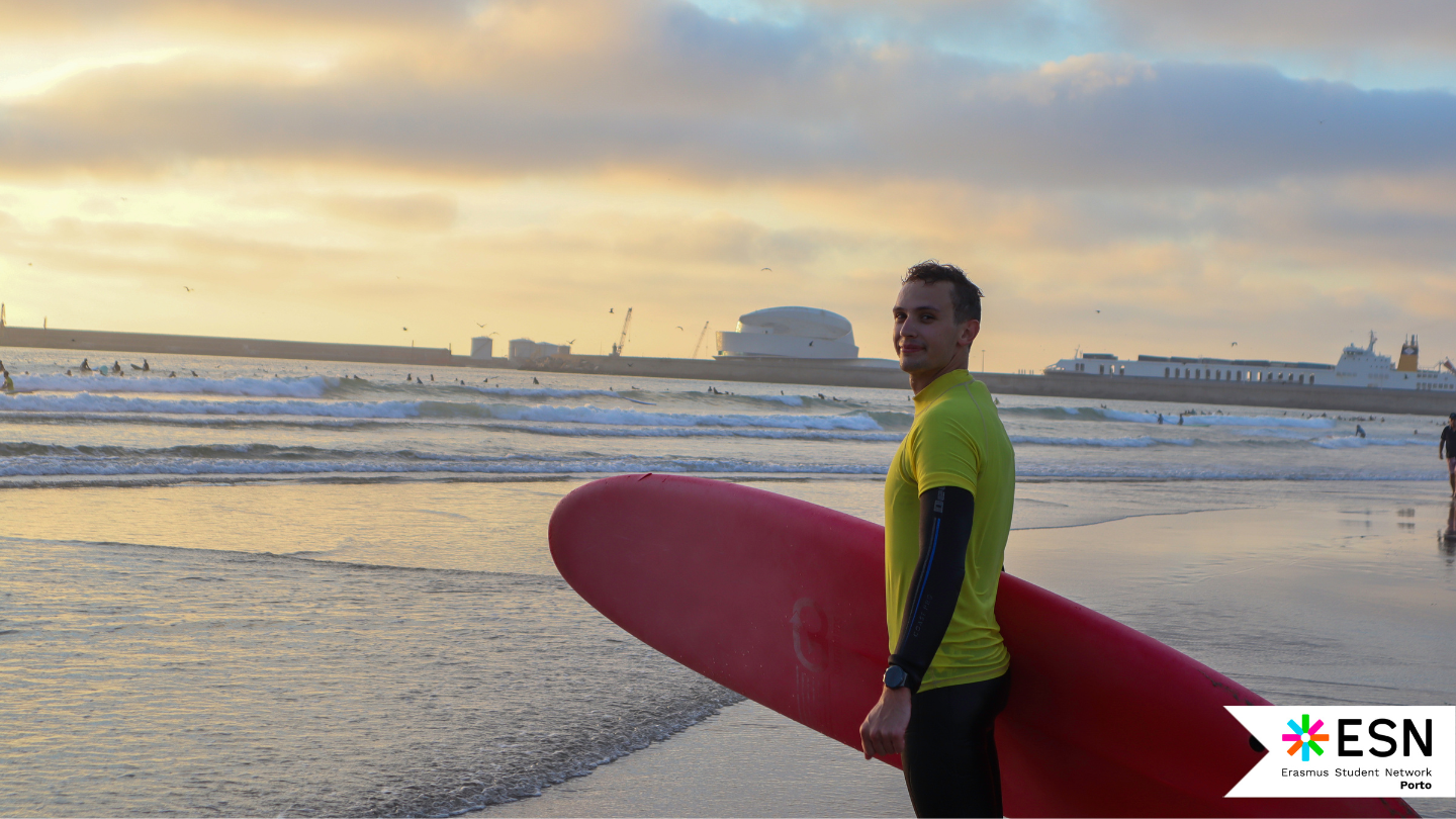 A person on the beach holding a surfboard.