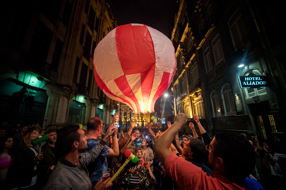 A photo of a small hot air balloon and people around it.