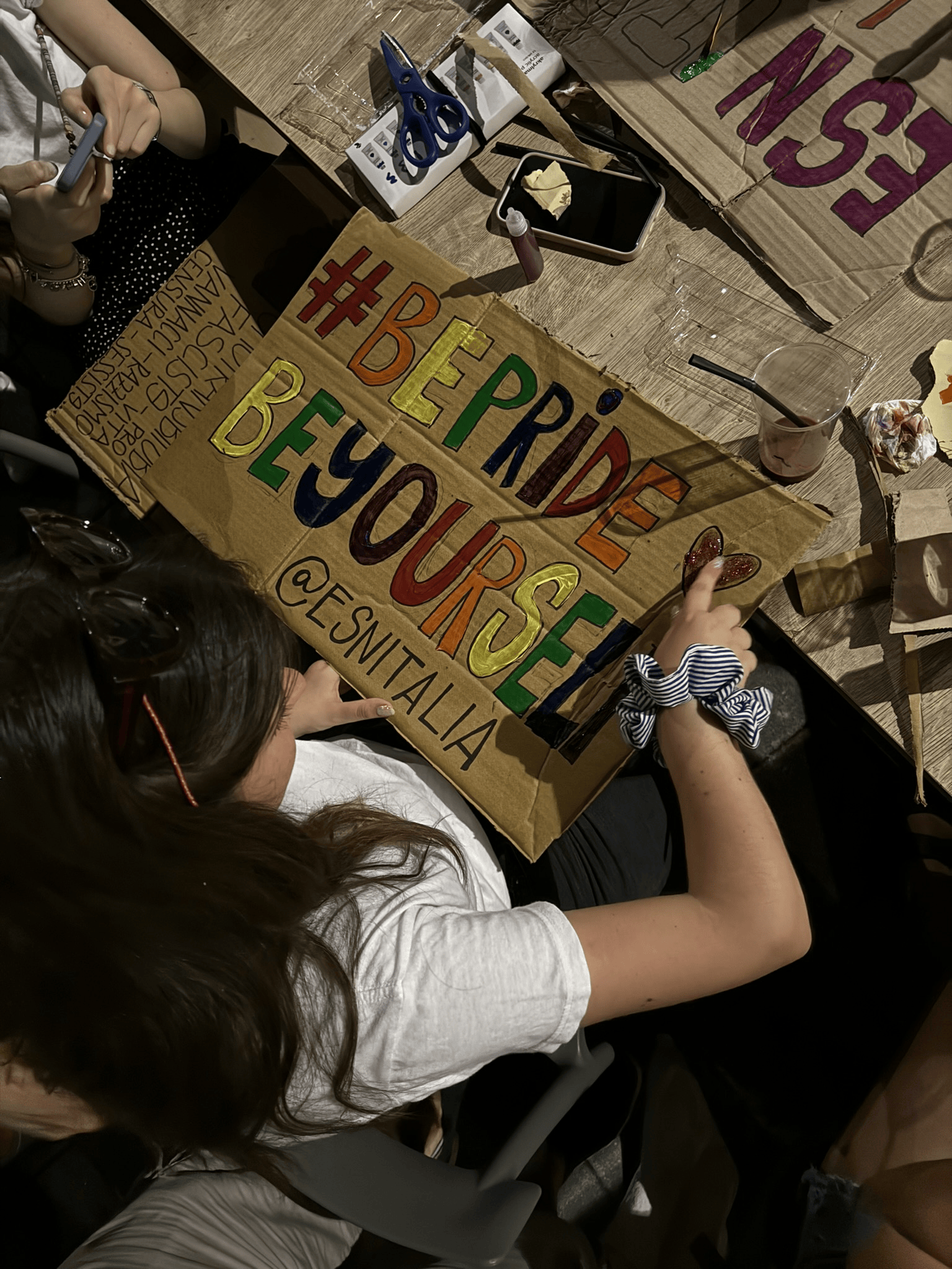 A volunteer writing a sign for the parade
