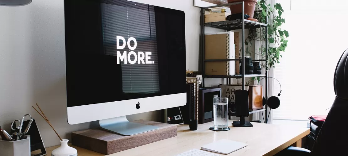 silver iMac with keyboard and trackpad inside room