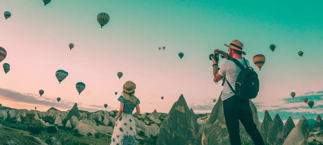 man taking photo of hot air balloons