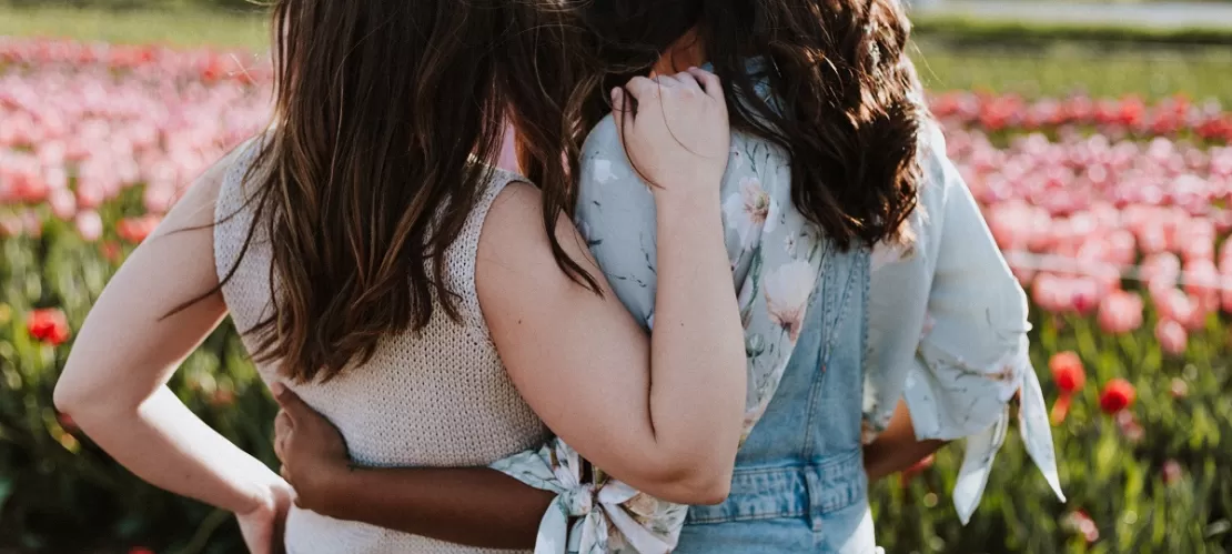 two women in front of flowers