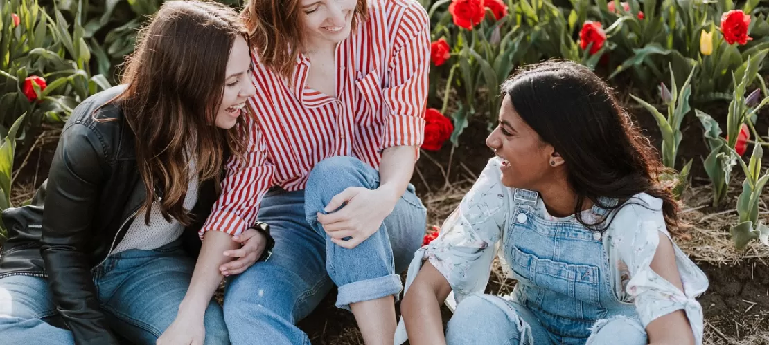 three woman sitting near the flower