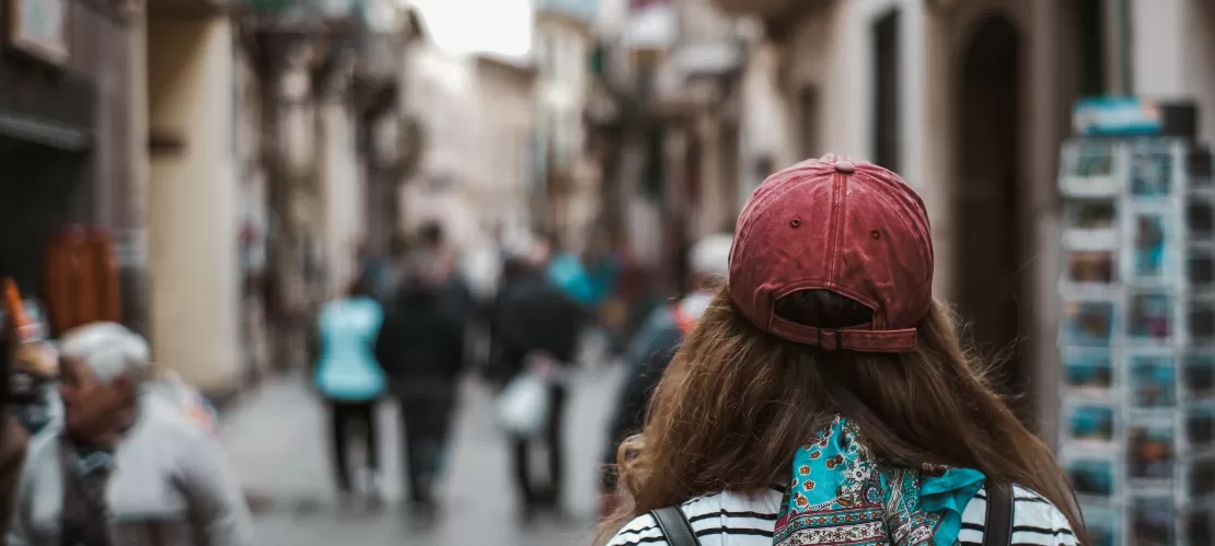 A girl standing in a street with her backpack